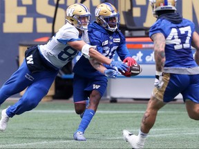 Winnipeg Blue Bombers wide receiver Drew Wolitarsky (left) reaches in to take an interception away from defensive back Winston Rose during practice on Monday.
