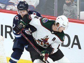 Winnipeg Jets forward Nikolaj Ehlers (left) catches an elbow in the chops from Arizona Coyotes defenceman Jakob Chychrun in Winnipeg on Mon., Nov. 29, 2021.  KEVIN KING/Winnipeg Sun/Postmedia Network