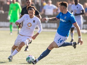 Edmonton FC Cale Loughrey (14) and Valour FC Sean Rea (24) vie for the ball during second half action in Edmonton on Oct. 8, 2022.