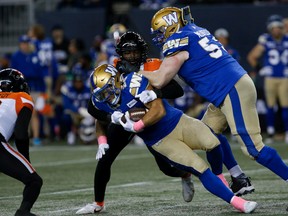 Winnipeg Blue Bombers' Brady Oliveira (20) gets tackled against the B.C. Lions during first half CFL action in Winnipeg Friday, October 28, 2022.