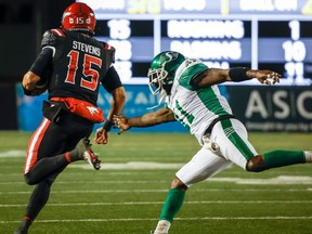 Saskatchewan Roughriders linebacker Larry Dean, right, reaches for Calgary Stampeders quarterback Tommy Stevens as he takes off on an 85-yard touchdown run Saturday at McMahon Stadium.