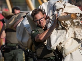 Conservation officers carry part of a teepee that has been taken down at the Manitoba legislature during a move to evict a protest camp on the north side of the grounds, in Winnipeg, Tuesday, Oct. 4, 2022.