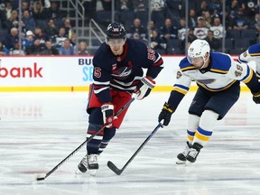 Winnipeg Jets forward Mark Scheifele (55) skates around St. Louis Blues forward Ivan Barbashev (49) during the second period at Canada Life Centre on Monday.  Terrence Lee-USA TODAY Sports