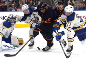 The Edmonton Oilers' Evander Kane (91) battles the Buffalo Sabres' Mattias Samuelsson (23) and Rasmus Dahlin (26) during first period NHL action at Rogers Place in Edmonton, Tuesday Oct. 18, 2022.