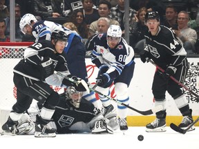 LOS ANGELES, CALIFORNIA - OCTOBER 27: Jonathan Quick #32 of the Los Angeles Kings looks for the puck behind Trevor Moore #12 and Pierre-Luc Dubois #80 of the Winnipeg Jets during the second period at Crypto.com Arena on October 27, 2022 in Los Angeles, California.