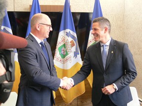 Winnipeg Mayor Brian Bowman (right) shakes hands with Mayor-Elect Scott Gillingham in the Mayor's office at Winnipeg City Hall on Friday.