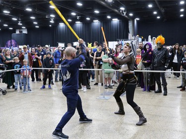 Matthew Gill (left) and Shandell Kenny from River City Jedi have a lightsabre duel during Winnipeg Comiccon at the RBC Convention Centre on Sunday, Oct. 30, 2022.