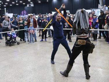 Matthew Gill (left) and Shandell Kenny from River City Jedi have a lightsabre duel during Winnipeg Comiccon at the RBC Convention Centre on Sunday, Oct. 30, 2022.