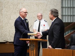 Winnipeg Mayor Scott Gillingham, left, gets sworn in during the inaugural meeting of city council at Winnipeg city hall on Tuesday, Nov. 1.