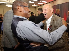 Mike Riley (right) and Rod Hill of the 1990 Winnipeg Blue Bombers say hello ahead of its induction into the Manitoba Sports Hall of Fame during a ceremony at the Victoria Inn in Winnipeg on Thursday.