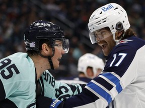 The Kraken’s Andre Burakovsky and Winnipeg Jets’ Adam Lowry rough each other up at Climate Pledge Arena in Seattle, Wash., Sunday night. Getty Images