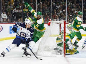 Jets defenceman Nate Schmidt is pursued by Wild winger Jordan Greenway as he carries the puck behind the Minnesota net on Wednesday night at Xcel Energy Center in St Paul, Minn.