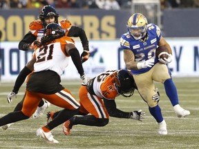 Winnipeg Blue Bombers running back Brady Oliveira (20) is tackled by BC Lions linebacker Ben Hladik (46) in the first half at Investors Group Field on Sunday.