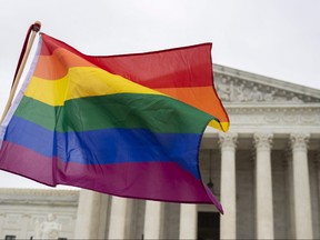 Supporters of the LGBT wave their flag in front of the U.S. Supreme Court, Oct. 8, 2019, in Washington.