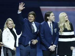 Former Winnipeg Jets' Teemu Selanne waves to the crowd during a ceremony where he and Teppo Numminen, right, were inducted into the Winnipeg Jets Hall of Fame Thursday night. JOHN WOODS/THE CANADIAN PRESS