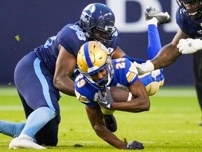 Winnipeg Blue Bombers' Greg McCrae is tackled by Toronto Argonauts' Ja'Gared Davis during the first half of CFL football action in Toronto, Monday, July 4, 2022.