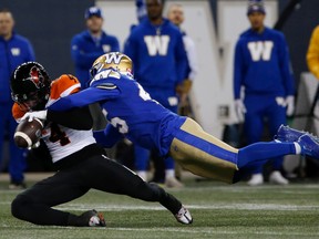 B.C. Lions' Keon Hatcher (4) hangs onto the pass against Winnipeg Blue Bombers' Jamal Parker (45) during first half CFL action in Winnipeg Friday, October 28, 2022.