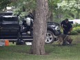 An RCMP officer works with a police dog as they move through the contents of a pickup truck on the grounds of Rideau Hall in Ottawa, Thursday, July 2, 2020. A Manitoba man who armed himself and rammed a gate at Rideau Hall to confront Prime Minister Justin Trudeau has been granted day parole after serving less than half his sentence.