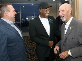 Paul Robson (right), James West (centre) and James Grieve from the 1990 Winnipeg Blue Bombers share a laugh ahead of the team induction into the Manitoba Sports Hall of Fame during a ceremony at the Victoria Inn in Winnipeg on Thursday, Nov. 3, 2022.
