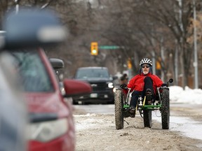 Stuart Croall struggles to pedal his recumbent tricycle along the unplowed cycling lane on Harrow Avenue in Winnipeg on Monday, Nov. 21, 2022.