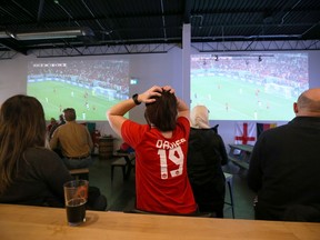 A woman wearing an Alphonso Davies jersey reacts to a near-miss from Canada while watching their World Cup soccer match against Belgium at Stone Angel Brewing on Pembina Highway in Winnipeg on Wed., Nov. 23, 2022.  KEVIN KING/Winnipeg Sun