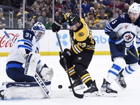 Boston Bruins left winger Brad Marchand looks for a rebound in front of Winnipeg Jets goaltender Connor Hellebuyck during the first period at TD Garden. USA TODAY Sports