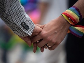 A same-sex couple hold hands during an event in Hong Kong on May 25, 2019.
