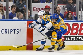 8 décembre 2022 ; Saint Louis, Missouri, États-Unis ; Le centre des Blues de St. Louis Robert Thomas (18 ans) et le centre des Jets de Winnipeg Michael Esimont (23 ans) se battent pour la rondelle au cours de la première période au Enterprise Center. Jeff Curry, USA Today Sports