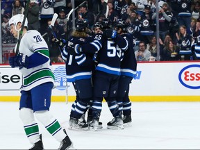 Winnipeg Jets forward Mark Scheifele (55) is congratulated by his teammates on his goal against the Vancouver Canucks during the second period at Canada Life Centre.