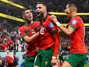 Morocco's forward Youssef En-Nesyri (centre) celebrates with teammates after scoring the opening goal during the Qatar 2022 World Cup quarter-final football match between Morocco and Portugal at the Al-Thumama Stadium in Doha on Saturday, Dec. 10, 2022.