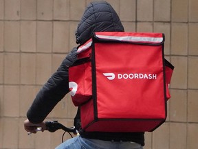 A delivery person for DoorDash rides his bike in the rain during the coronavirus disease (COVID-19) pandemic in the Manhattan borough of New York City, New York, U.S., on Nov. 13, 2020.