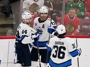 Winnipeg Jets center Adam Lowry (17) celebrates his goal with defenceman Josh Morrissey (44) during the third period at United Center in Chicago on Friday, Dec. 9, 2022.