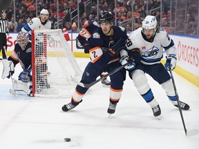 Edmonton Oilers defenceman Evan Bouchard (2) and Winnipeg Jets centre Kevin Stenlud (28) battle in front of Oilers goalie Jack Campbell (36) during the second period at Rogers Place in Edmonton on Saturday, Dec. 31, 2022.