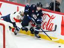 Josh Morrissey (44 ans) des Jets de Winnipeg patine loin de l'attaquant des Panthers de la Floride Zack Dalby (22 ans) au cours de la troisième période au Canada Live Centre à Winnipeg le mardi 6 décembre 2022.