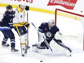 Winnipeg Jets defenceman Dylan DeMelo (2) and Nashville Predators centre Cody Glass (8) watch an incoming shot on Winnipeg Jets goaltender Connor Hellebuyck (37) in the third period at Canada Life Centre. James Carey Lauder-USA TODAY Sports