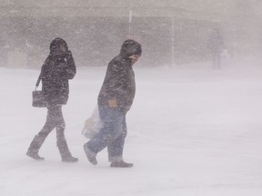 Pedestrians walk through blizzard-like conditions in Brantford, Ontario, on December 23, 2022.
