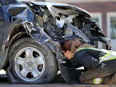 A tow truck operator secures a car involved in a two-vehicle collision north of the Osborne Street bridge over the lunch hour in Winnipeg that snarled traffic for hours on Tues., May 3, 2022.