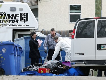 A forensics officer and others look over a pile of garbage as police investigate a homicide after human remains later determined to be those of Rebecca Contois were found in the 200 block of Edison Avenue in Winnipeg on Mon., May 16, 2022. Jeremy Skibicki has since been charged in the murders of three other women, two of whose remains are believed to be in a landfill north of the city, sparking battles between family and authorities over a possible search.