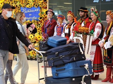 Refugees are greeted by volunteers from the Rusalka Ukrainian Dance Ensemble as the first federal charter of refugees arrive at Winnipeg International Airport on Mon., May 23, 2022.