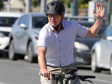 Mayoral candidate Scott Gillingham, elected to the chair in a seesaw victory over Glen Murray in October, signals a right-hand turn as he arrives on bicycle at ManyFest street festival in downtown Winnipeg on Sun., Sept. 11, 2022.