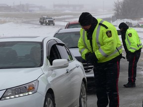 Winnipeg Police officers speak with motorists during a check stop on Roblin Boulevard, westbound at exit ramp to south Perimeter in Winnipeg on Friday. The RCMP and Winnipeg Police are joining forces to target impaired drivers at various locations in and around the City of Winnipeg, to mark National Impaired Driving Enforcement Day on Saturday. The RCMP will also be doing further enforcement in rural Manitoba.