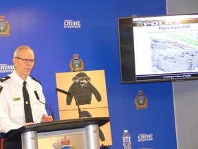 Insp. Cam MacKid of the Winnipeg Police forensics unit speaks at a press conference at Winnipeg Police headquarters  on Tuesday, Dec. 6, 2022, answering questions regarding the search for the remains of two murdered women believed to be in a landfill north of the city. An image of the Prairie Green landfill can be seen on the monitor.