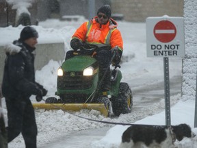 A person clears snow in Winnipeg on Wednesday as a system settled in over the city. Chris Procaylo/Winnipeg Sun