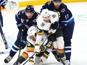 Vegas Golden Knights forwards Keegan Kolesar (bottom left) and Nicolas Roy (centre) collide with help from Winnipeg Jets defenceman Dylan Samberg (left) and centre Adam Lowry at Canada Life Centre on Tues., Dec. 13, 2022.