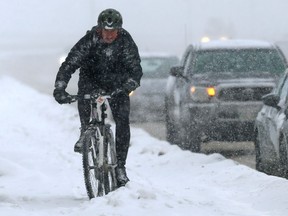 A cyclist negotiates a snow-filled sidewalk along Donald Street in Winnipeg on Wed., Dec. 14, 2022.  KEVIN KING/Winnipeg Sun