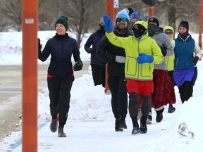 Winnipeg ultramarathon runner Junel Malapad (in red) passes the Canadian Museum for Human Rights with some of his supporting runners as his sixth annual Change Boxing Day to Running Day event in support of Siloam Mission begins on Sunday, Dec. 26, 2021.