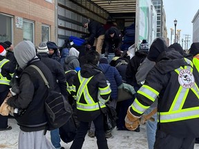 Volunteers from the Bear Clan Patrol hand out warm clothing at the Salvation Army Centre of Hope on Henry Street in Winnipeg on Sunday, Dec. 25, 2022. Volunteers also handed out warm clothing at the warming space to 190 Disraeli Freeway and at Siloam Mission.