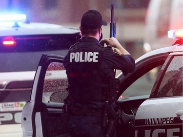 A Winnipeg Police officer with a shotgun near where a person sustained an apparent gunshot wound in their back.