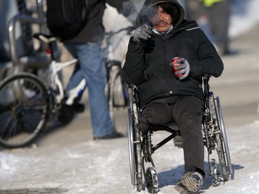 A person who is using a wheelchair for mobility takes a break on a snow covered sidewalk in Winnipeg on Friday, Feb. 25, 2022.