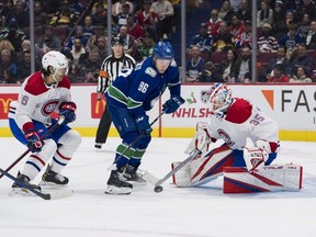 Canadiens defenceman Johnathan Kovacevic (26) looks on as goalie Sam Montembeault (35) makes a save on Canucks forward Andrei Kuzmenko (96) in the first period at Rogers Arena in Vancouver, Dec. 5, 2022.